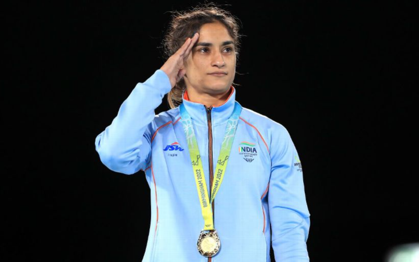 Vinesh Phogat in an Indian team jersey, saluting while wearing her Birmingham 2022 Commonwealth Games gold medal.